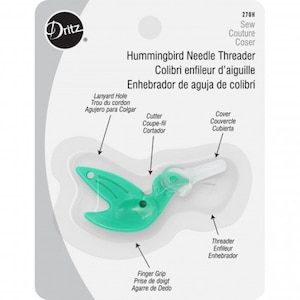 May include: A green plastic hummingbird needle threader with a white cutter and a white cover. The threader has a finger grip and a lanyard hole. The text on the packaging reads "Hummingbird Needle Threader, Colibri enfileur d'aiguille, Enhebrador de aguja de colibrí, Sew Couture Coser, 270H".