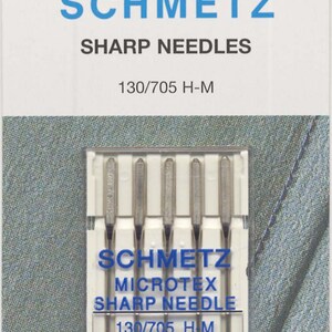 May include: A package of six silver sewing needles, labeled "Schmetz Microtex Sharp Needle 130/705 H-M 80/12".