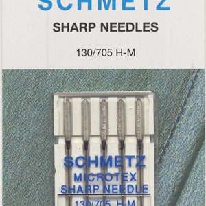 Puede incluir: Un paquete de seis agujas de máquina de coser plateadas, etiquetadas como "Schmetz Microtex Sharp Needle 130/705 H-M 90/14".