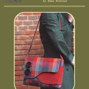 May include: A messenger bag with a red, blue, and purple plaid design. The bag features a red flap and two large, dark brown buttons. The text "Charlie's Aunt" and "Brancaster Messenger Bag" are displayed on the image.