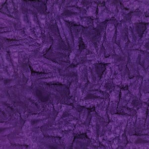 Puede incluir: Primer plano de una tela de felpa de color púrpura intenso. El material tiene un patrón texturizado y en relieve, creando una superficie visualmente interesante. El color de la tela es consistente en todas partes, con sutiles variaciones de luz y sombra que añaden profundidad.