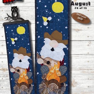 May include: A fabric wall hanging featuring a gnome playing a guitar by a campfire under a starry night sky. The design includes a yellow moon, bees, and the text "Campfire Clyde." The dimensions are 6" x 20". Skill level: Easy.