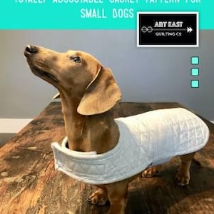 May include: A dachshund wearing a white quilted jacket. The image includes text that reads "THE DANDY-DOO TOTALLY REVERSIBLE, TOTALLY ADJUSTABLE JACKET PATTERN FOR SMALL DOGS" and "QUILT JACKET PATTERN FOR YOUR BEST FRIEND".