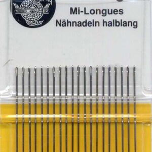 May include: A package of 20 John James quilting needles, size 8, made in England. The needles are silver and are packaged in a clear plastic case with a yellow background. The package also includes the text "Quilting", "Mi-Longues", "Nähnadeln halblang", and "Finest Quality English Needles".