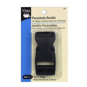 May include: Black plastic parachute buckle for 1 inch strap. Dritz brand packaging with the text "Parachute Buckle" and "Hebilla Paracaídas".