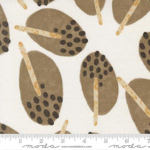 May include: White fabric with a repeating pattern of brown oval shapes with dark brown dots and tan stick-like accents. The fabric has a ruler along the bottom edge, with the "moda" logo and website address.