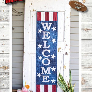 May include: A patriotic welcome banner with the words "WELCOME" in white on a blue background with white stars. The top and bottom have red and white stripes. The banner is 13 inches wide and 51 inches long.