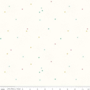 Puede incluir: Tela blanquecina con un patrón disperso de pequeños puntos de colores. Los puntos son de color rosa, amarillo y turquesa. La tela tiene una textura sutil y moteada. La imagen incluye una regla en pulgadas.