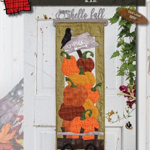 Könnte beinhalten: Ein Wandbehang aus Stoff mit Herbstthema, der gestapelte orangefarbene und braune Kürbisse in einem Holzkarren zeigt. Auf dem Banner steht "Peck & Pick'n Pumpkins" und "hello fall". Die Abmessungen betragen 30,5 cm x 94 cm. Eine schwarze Krähe sitzt über einem Schild mit der Aufschrift "U-PICK".