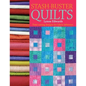 Op de afbeelding: Een boek getiteld Stash-Buster Quilts door Lynne Edwards met een raster van kleurrijke stoffen vierkanten met patronen in blauw-, paars- en rozetinten, naast een stapel gevouwen stoffen in verschillende effen kleuren aan de linkerkant.