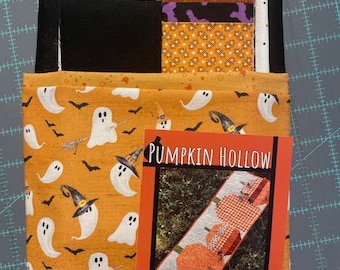 Pode incluir: Um conjunto de tecidos com várias estampas temáticas de Halloween em laranja, preto, verde e branco, incluindo fantasmas, morcegos e chapéus de bruxa. Um livreto de padrões intitulado Pumpkin Hollow de Tricia Lynn Maloney está incluído.