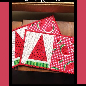 May include: Three watermelon-themed quilted snack mats. The mats are red and white gingham with watermelon slices and a single watermelon slice in the center. The mats are made by Tricia Lynn Maloney, Orphan Quilt Designs.