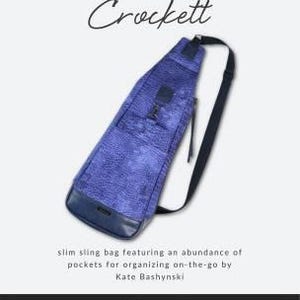 May include: A blue sling bag with a textured pattern, black strap, and a dark blue base. The bag is labelled "Crockett" and is designed for organising on-the-go. The bag is from Sallie Tomato, a source for sewing patterns and supplies.