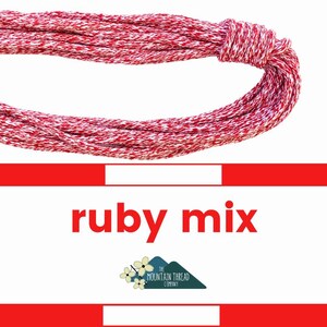 May include: A bundle of red and white twisted thread, knotted at one end, against a white background. The text "ruby mix" is displayed in red, along with a logo for The Mountain Thread Company.