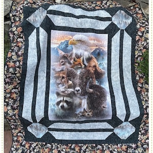 May include: A quilt pattern called "Sliders" featuring a panel with a variety of animals including an eagle, wolf, fox, raccoon, and owl. The panel is surrounded by a black and white border with a leaf pattern border. The text "Sliders" and "A Versatile Panel Quilt" is at the top of the image. The text "Quilting Renditions" and "My Design...Your Beautiful Rendition" is at the bottom of the image.