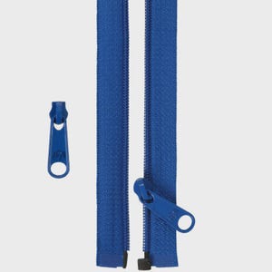May include: A close-up of a blue zipper with a matching zipper pull. The zipper is open, revealing the teeth. The zipper pull is a solid blue color with a circular hole. The zipper is a common sewing supply.