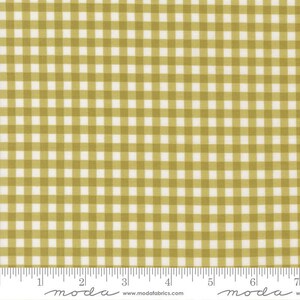 May include: A fabric with a gingham pattern in olive green and white. The fabric is marked with a ruler along the bottom edge. The text "moda" and "www.modafabrics.com" are printed on the bottom edge.