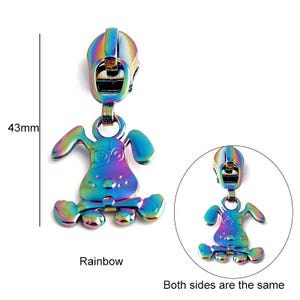 May include: A rainbow colored metal zipper pull shaped like a cartoon dog. The zipper pull is 43 mm tall. Both sides of the zipper pull are the same.