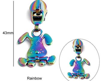 Op de afbeelding: Een regenboogkleurige metalen rits-trekker in de vorm van een cartoon-hond. De rits-trekker is 43 mm hoog. Beide kanten van de rits-trekker zijn hetzelfde.