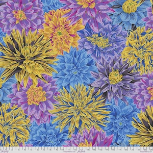 Op de afbeelding: Een stofpatroon met een dichte schikking van dahlia-bloemen in tinten geel, paars en blauw. Een wit meetlint met zwarte markeringen is zichtbaar langs de onderrand, met metingen van 0 tot 60 centimeter.