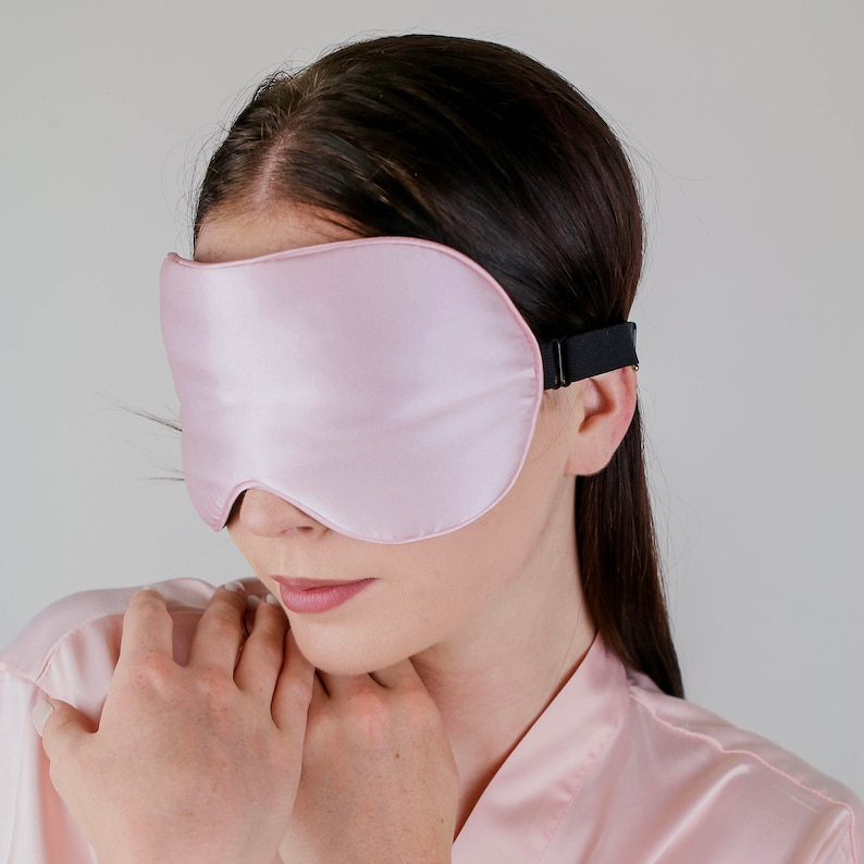 Puede incluir: Una m&aacute;scara para dormir de sat&eacute;n rosa con una banda el&aacute;stica negra. La m&aacute;scara est&aacute; dise&ntilde;ada para bloquear la luz y promover el sue&ntilde;o.