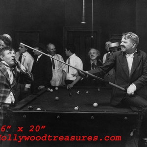 Peut inclure: Une photo en noir et blanc d'un groupe d'hommes jouant au billard. L'homme au premier plan tient une queue de billard et s'apprête à tirer. La table de billard est verte et a une surface en feutre noir. La photo mesure 16 pouces par 20 pouces.
