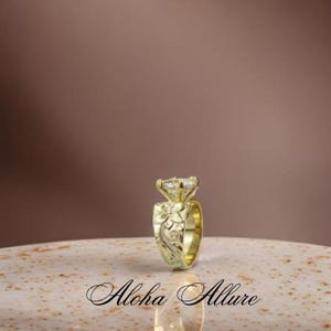 May include: A gold engagement ring with a large, clear, square-shaped diamond. The band is intricately carved with a floral design.