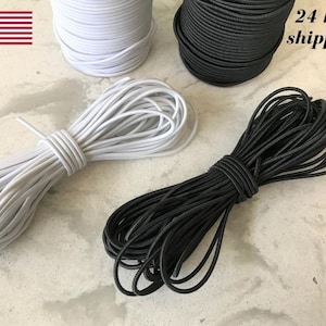 May include: Spools of white and black elastic cord. The white cord is bundled in a coil, and the black cord is in a separate coil. The American flag is in the upper left corner.