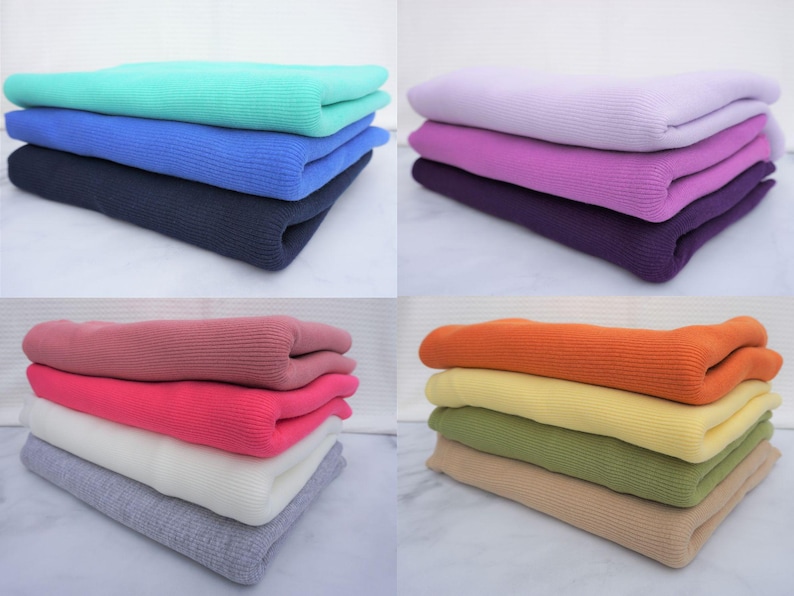 May include: Four stacks of folded knit sweaters in various colors. The stacks include shades of teal, blue, and navy; purple, pink, and lavender; pink, red, white, and gray; and orange, yellow, green, and tan.