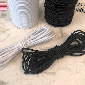 May include: White and black elastic cord rolls and bundles. The image shows two large rolls of elastic cord, one white and one black, along with two smaller bundles of the same colors. The text "24 hr. shipping" is visible.
