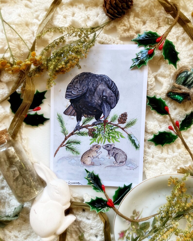 May include: A black crow perched on a snowy branch with green holly berries. Two small brown mice are on the ground below, one looking up at the crow and the other looking at the viewer. The image is a watercolor painting with a white background.