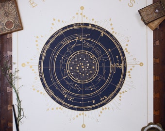 Può includere: Un poster color crema con un design celeste blu scuro e oro. La parola "EPHEMERIS" è in alto, con "2025" sotto. Il design centrale è una mappa stellare circolare. Sono inclusi inchiostro, una penna e piccole scatole decorative.