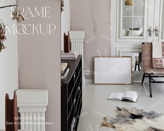 May include: A white frame mockup with a gold border, sitting on a white floor in a room with a white wall and a black dresser. The frame is empty and ready for your design.