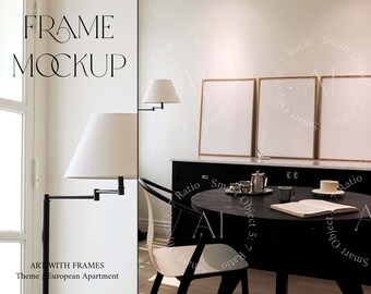 Può includere: Un mockup di tre stampe incorniciate in un soggiorno moderno. Le cornici sono rettangolari e hanno una finitura in legno chiaro. Le stampe sono vuote e bianche. La stanza è arredata in stile minimalista con un tavolo e sedie nere. Il tavolo ha un libro e una tazza di caffè sopra. La stanza ha una grande finestra con tende bianche.