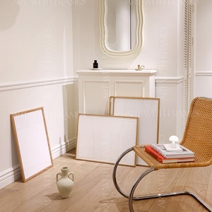 May include: A white room with a white, wavy mirror, a white cabinet, and three framed prints. A wicker chair with a chrome frame sits in the corner of the room. A ceramic vase sits on the floor. The text "ART WITH FRAMES" appears in the image.