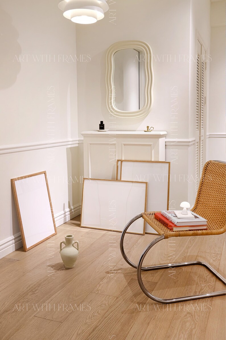 May include: A white room with a white, wavy mirror, a white cabinet, and three framed prints. A wicker chair with a chrome frame sits in the corner of the room. A ceramic vase sits on the floor. The text "ART WITH FRAMES" appears in the image.