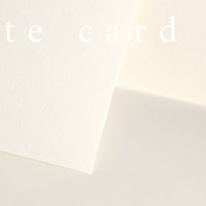 May include: Three pieces of white card stock, arranged in an overlapping pattern. The top piece has the text "white card" printed on it.