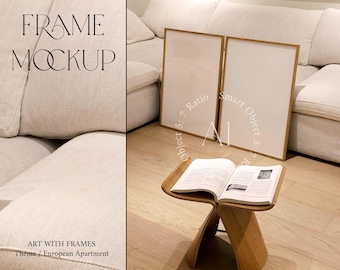 May include: Two wooden picture frames with white mats and blank white interiors are leaning against a white couch. The frames are on a light wood floor. A book is on a wooden stool in front of the couch.