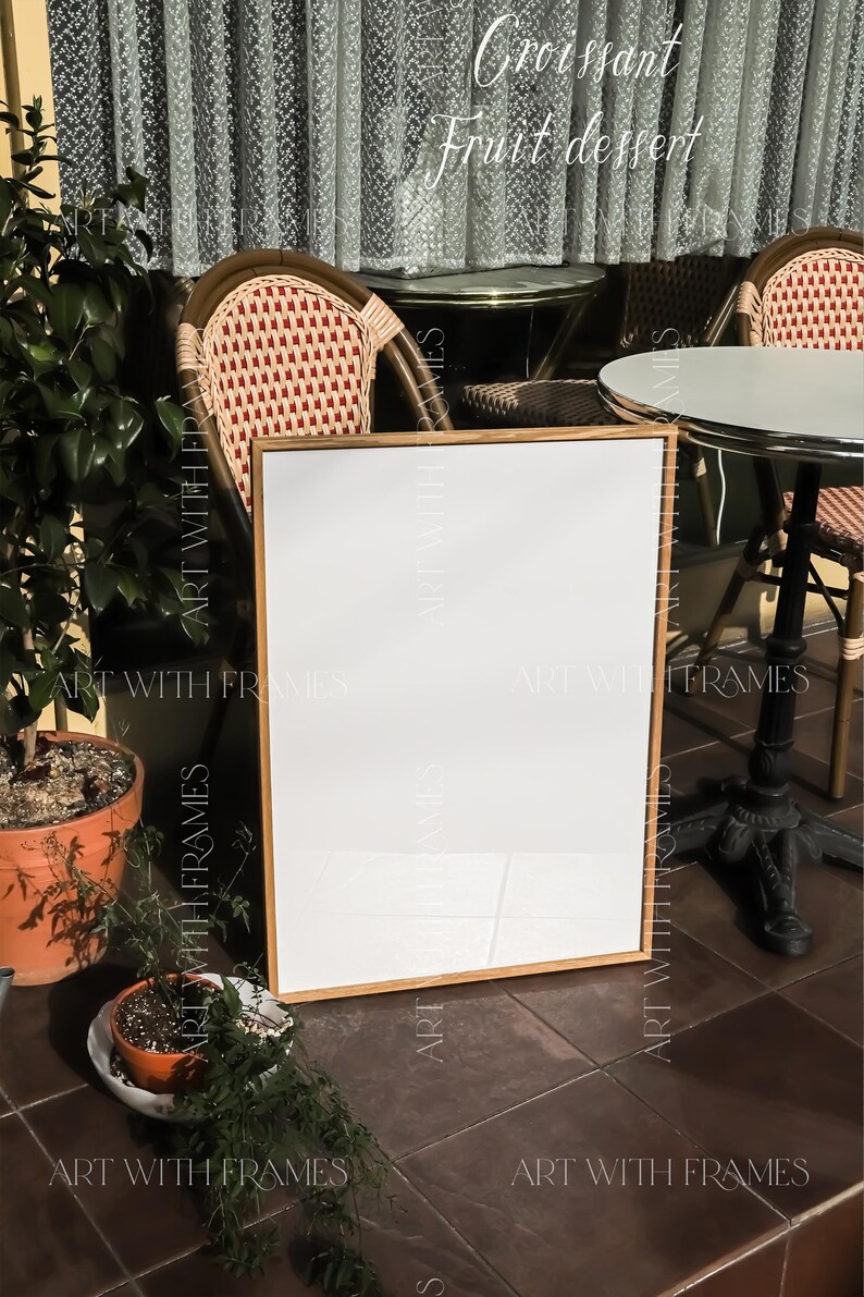May include: A white sign with a wooden frame sits on a tiled floor in front of two wicker chairs and a table with a white tabletop. The sign is blank and ready for text. The sign is in front of a window with a sheer curtain. The text "Croissant Fruit dessert" is written in cursive above the sign.