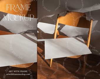 May include: A white frame mockup on a wooden chair with a white background. The frame is sitting on the chair seat and is illuminated by sunlight. The text "FRAME MOCKUP" is visible at the top of the image. The text "ART WITH FRAME" and the website address "artwithframemockup.com" are visible at the bottom of the image.