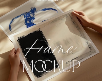 May include: A white frame mockup with a black and white abstract painting inside. The frame is on a wooden surface with natural light shining through.