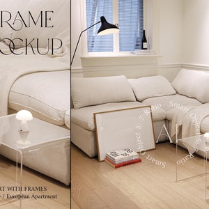 Puede incluir: Un sofá seccional blanco con una manta y una mesa de café de vidrio con una pequeña lámpara blanca. Un cuadro enmarcado se apoya en el sofá. La habitación tiene un suelo de madera clara y paredes blancas.