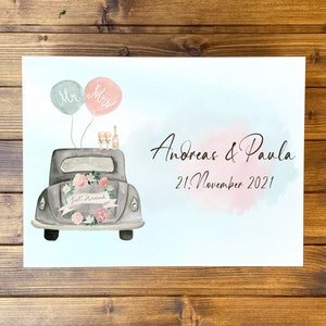 May include: A watercolor print featuring a gray vintage car decorated with a floral wreath and a Just Married banner. Above the car are two balloons labeled Mr and Mrs, two champagne flutes, and a bottle. Text reads Andreas & Paula 21. November 2021.