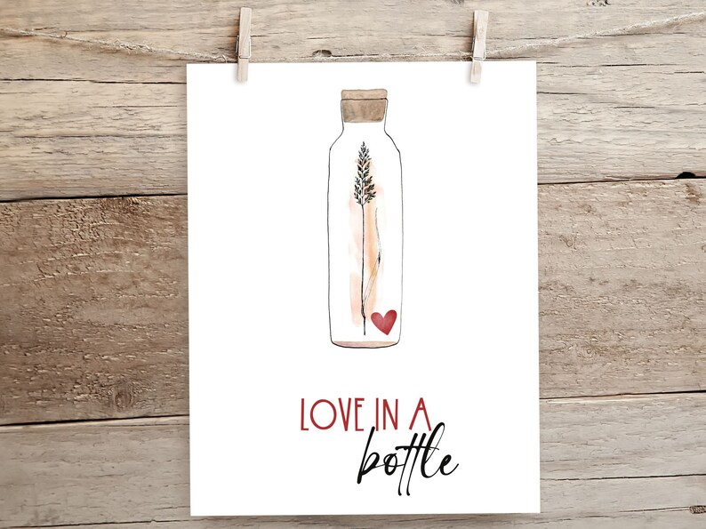 May include: A watercolour illustration of a glass bottle with a cork stopper. Inside the bottle is a single stalk of wheat and a small red heart. The text "LOVE IN A BOTTLE" is written below the bottle.