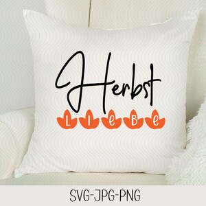May include: White pillow with the text "Herbst Liebe" in black lettering and five orange leaf shapes with the letters "L I E B E" in black lettering.
