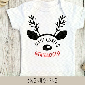 May include: White baby onesie with a black reindeer design and the text "Mein erstes Weihnachten" in red and black.