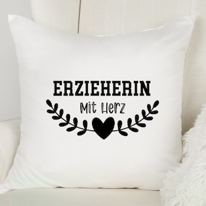 May include: White pillow with black text that reads "ERZIEHERIN Mit Herz" and a black heart.
