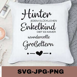 Puede incluir: Almohada blanca con texto negro que dice "Hinter jedem glücklichen Enkelkind gibt es immer wundervolle Großeltern" con un corazón negro entre dos puntos. El texto está en alemán.