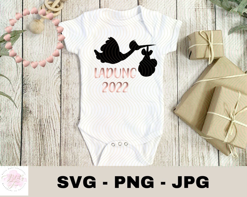 May include: White baby onesie with a black stork silhouette carrying a baby bundle. The text "LADUNG 2022" is printed in pink on the onesie.