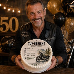 Puede incluir: Un pastel redondo blanco con un gr&aacute;fico impreso de una motocicleta y el texto en alem&aacute;n T&Uuml;V-BERICHT, junto con iconos de a&ntilde;o, edad y kilometraje. El pastel tiene un borde de glaseado blanco festoneado y es sostenido por una persona con chaleco.